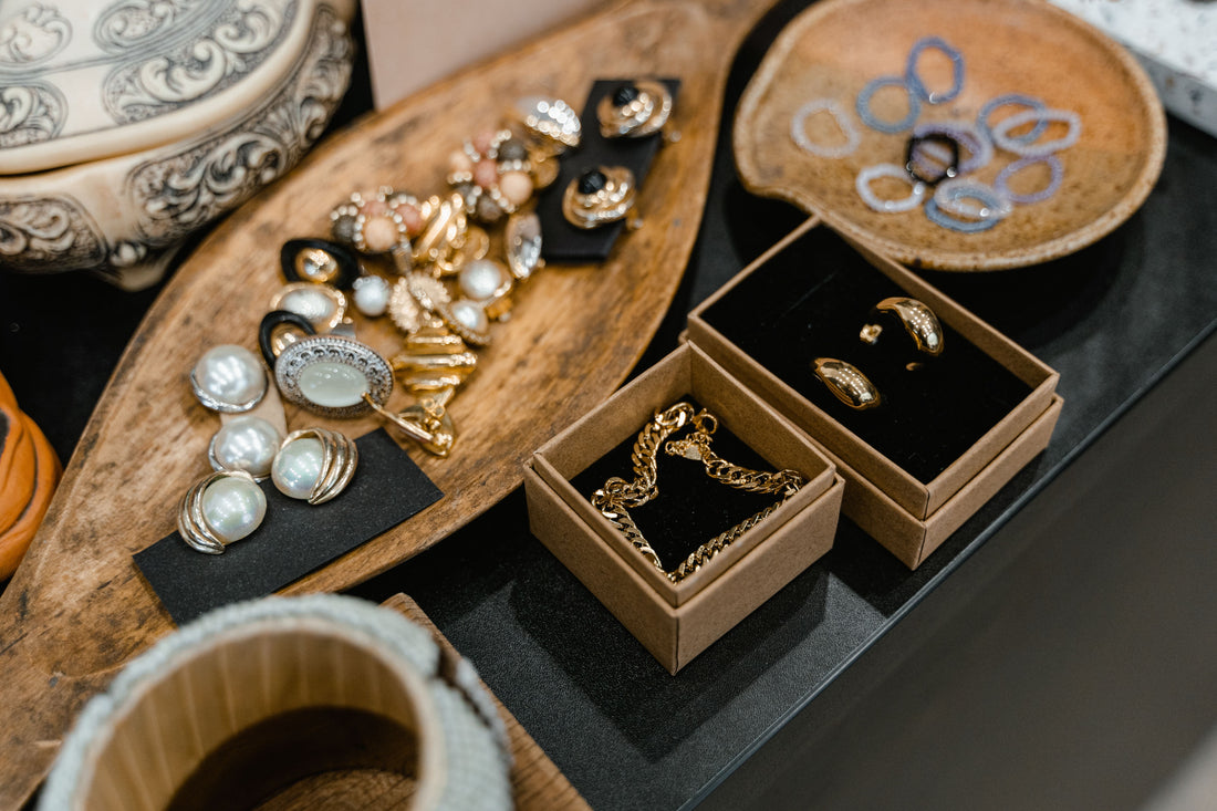 Assorted pre-owned jewelry and accessories arranged on wooden trays