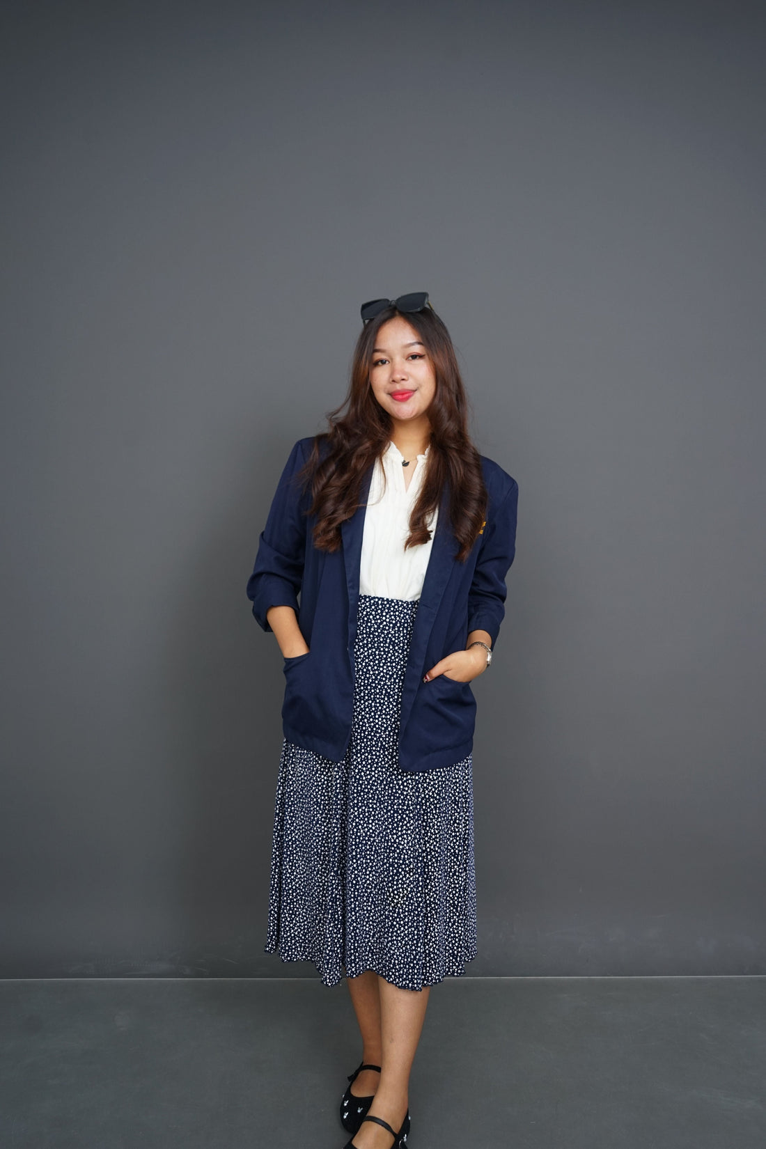 Confident portrait of a woman in a tailored navy blazer, representing the polished American ready-to-wear silhouettes collected in CENT'ANNII's guide to pre-owned Banana Republic