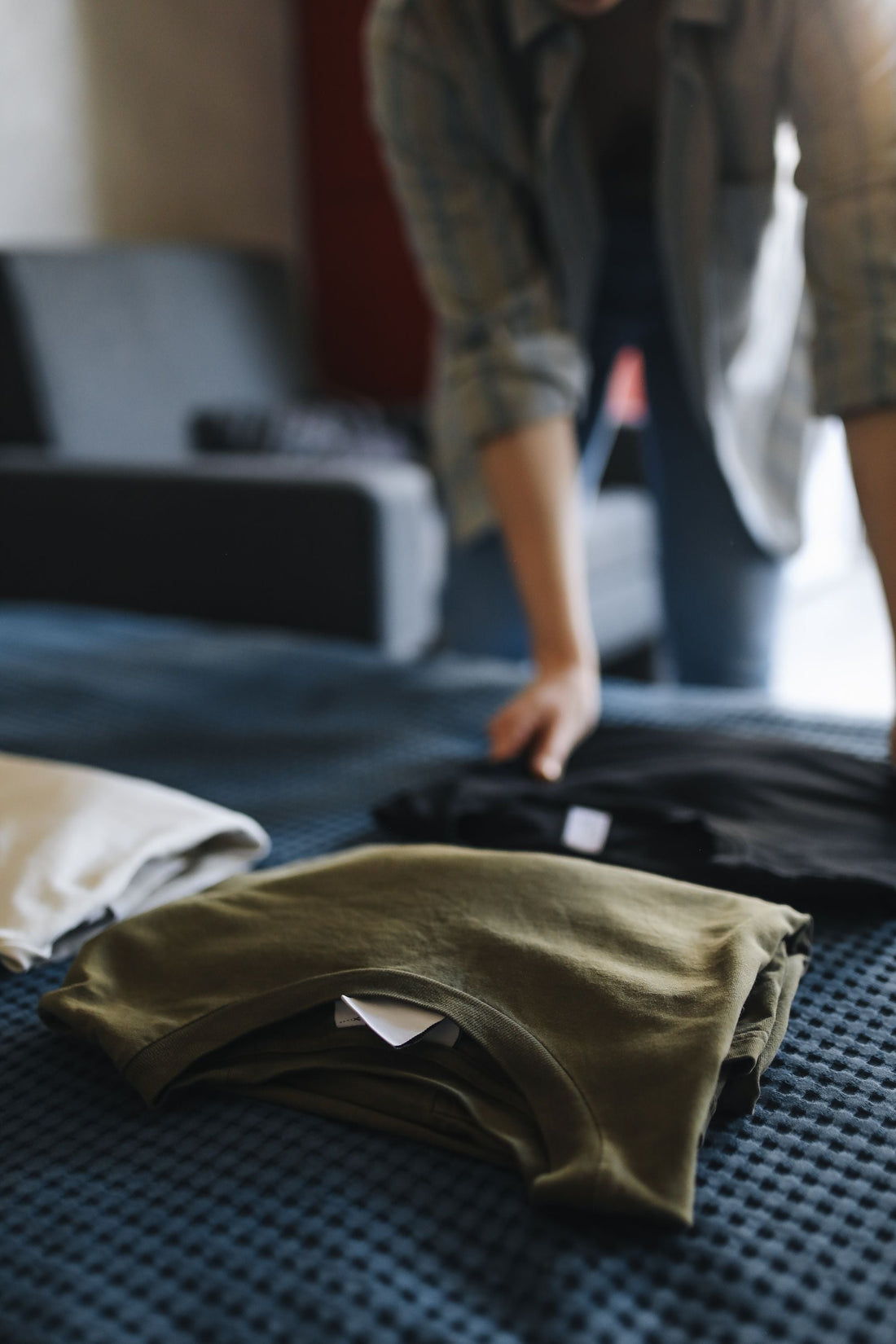Neatly folded cotton t-shirts stacked in soft neutral tones