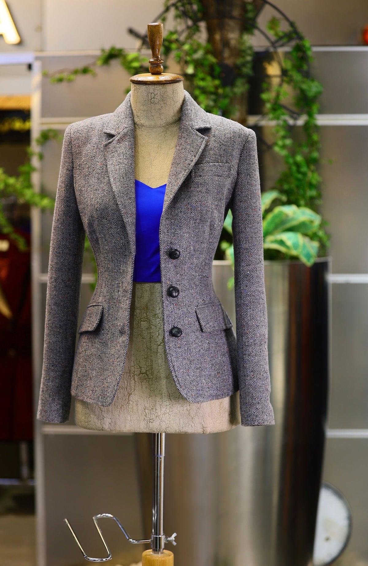 Tailored gray wool blazer displayed on a mannequin, representing the quality construction to look for when authenticating designer clothing