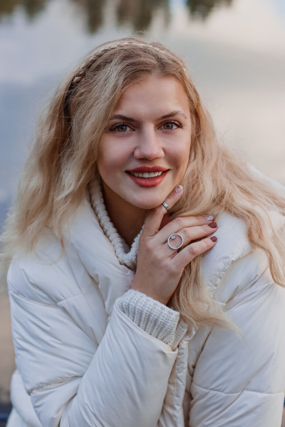 Woman in a white puffer jacket standing outdoors in natural daylight, representing the down outerwear covered in CENT'ANNII's pre-owned puffer care guide