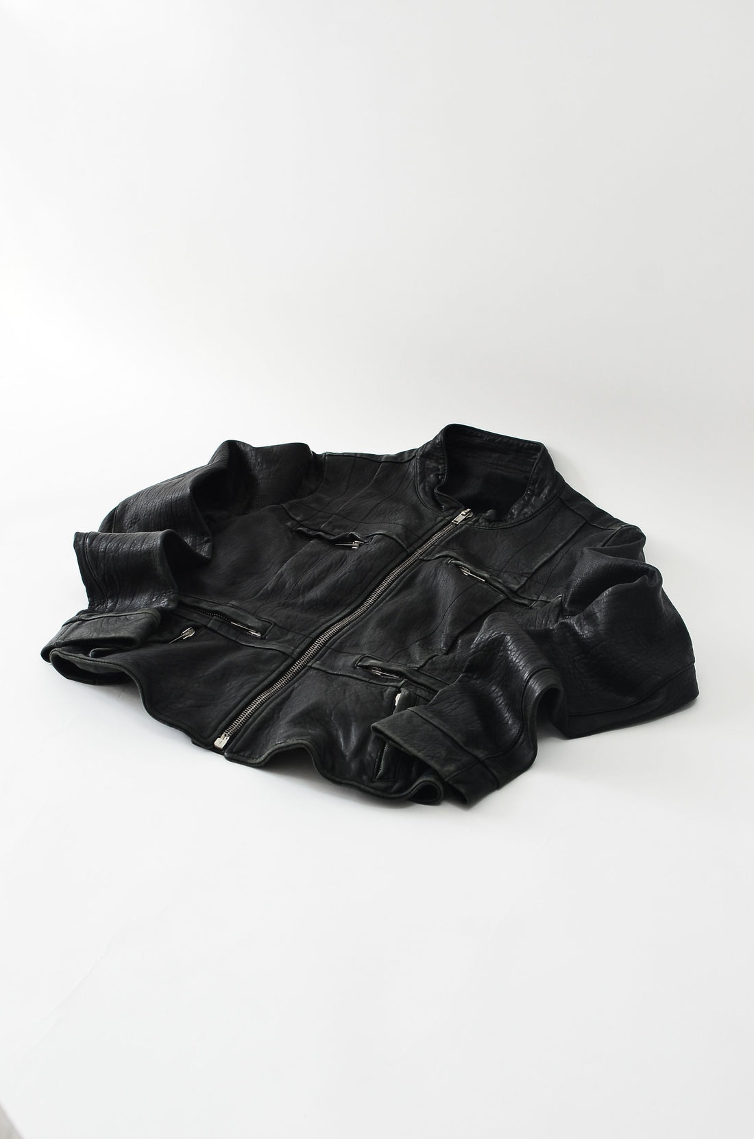 Black faux leather jacket laid flat, illustrating pre-owned faux leather care