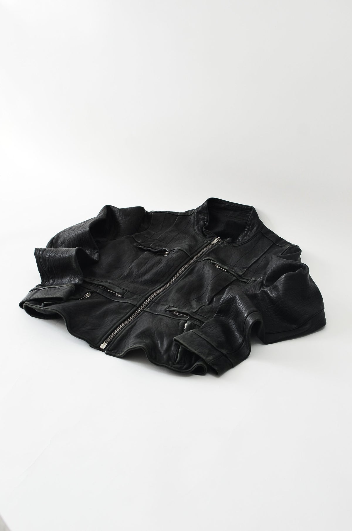 Black faux leather jacket laid flat, illustrating pre-owned faux leather care