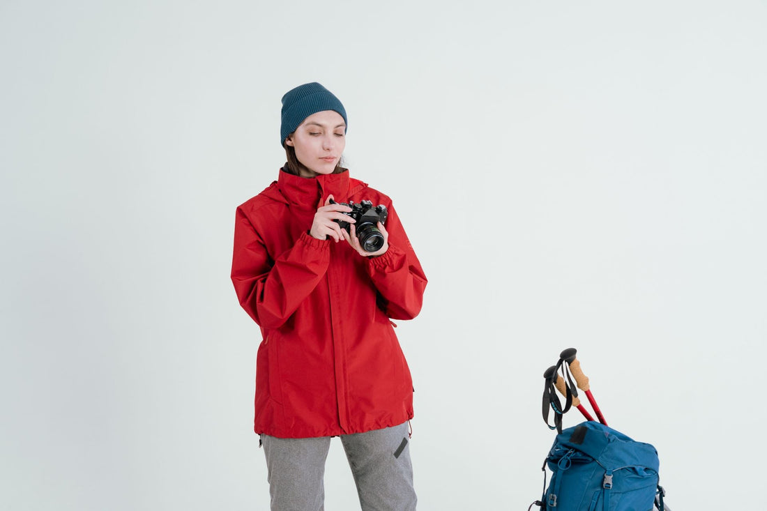 Woman in a red technical windbreaker jacket outdoors, representing the durable outerwear from brands like Patagonia, Columbia, and The North Face featured in CENT'ANNII's pre-owned outdoor brand guide