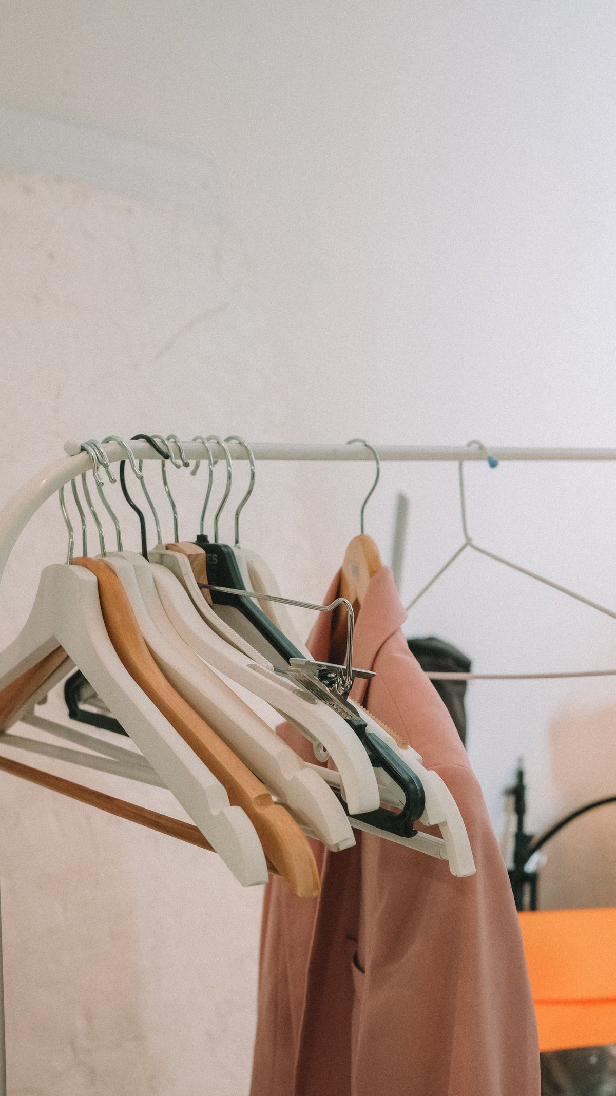 Elegant neutral blazers hanging on a minimalist clothes rack, capturing the understated, quality-first ethos of quiet luxury