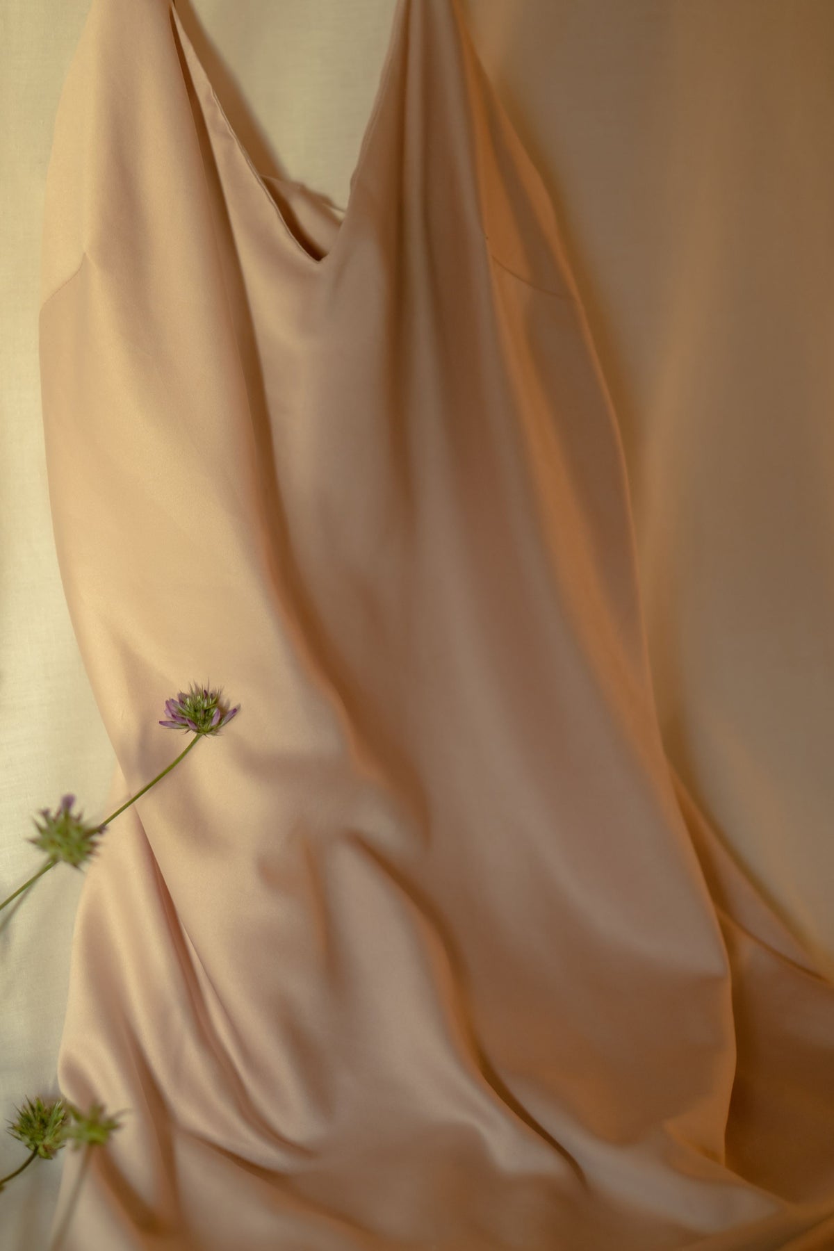 Beige silk evening dress draped elegantly with delicate floral accents