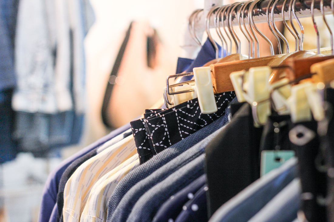 A curated collection of clothing hanging in a boutique, representing thoughtful, sustainable wardrobe choices
