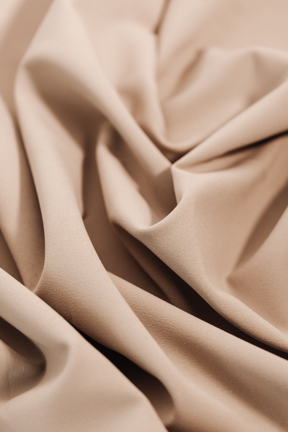 Close-up of soft taupe woven fabric showing texture and folds