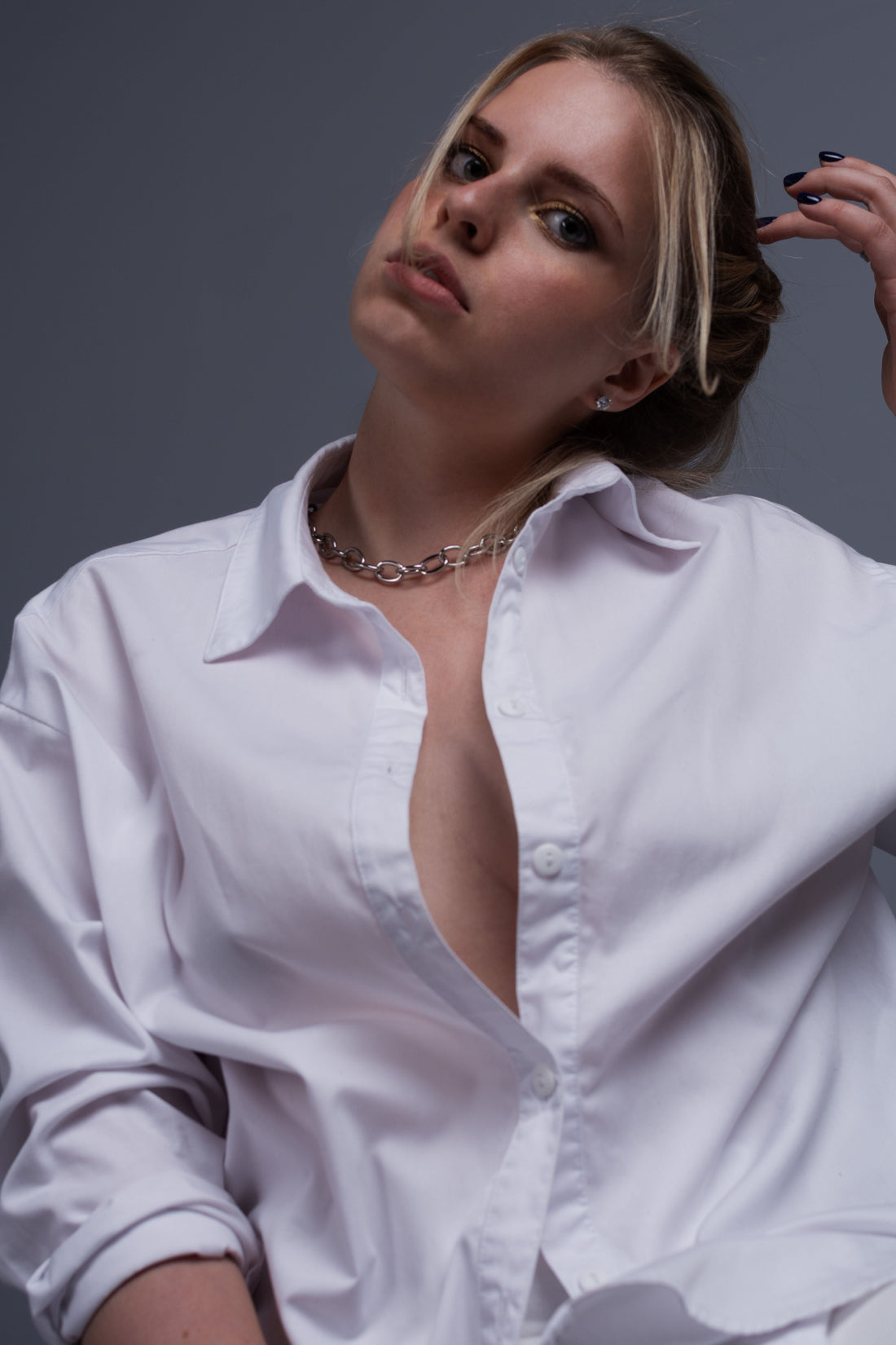 Elegant studio portrait of a woman in a crisp white button-down shirt, representing the versatile styling piece featured in CENT'ANNII's guide