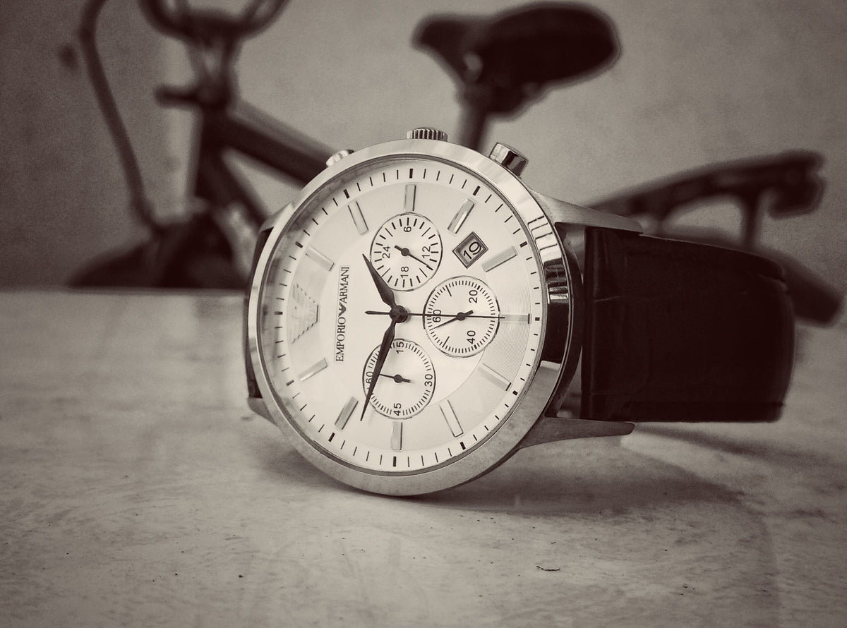 Close-up of a classic stainless steel wristwatch with a black leather strap