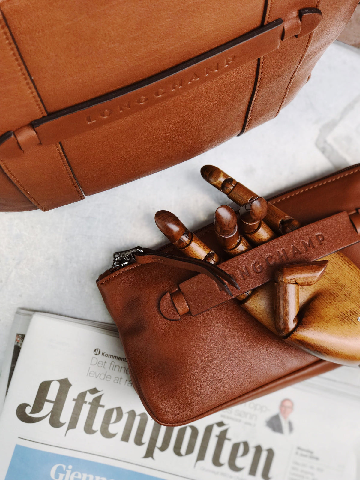 Editorial flat lay of a brown leather designer handbag, representing the value of pre-owned designer fashion